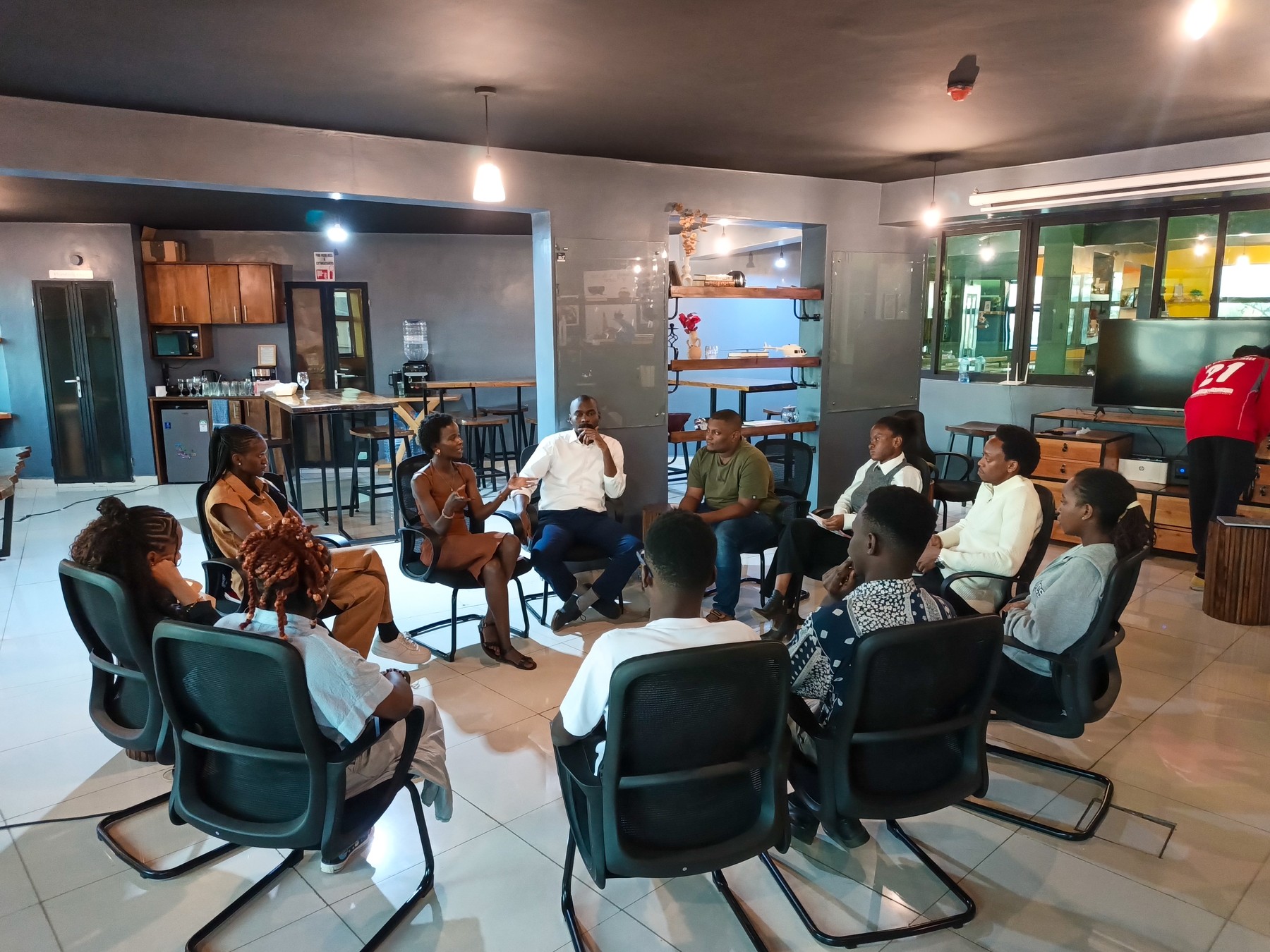 People seated in a circle, listening and discussing