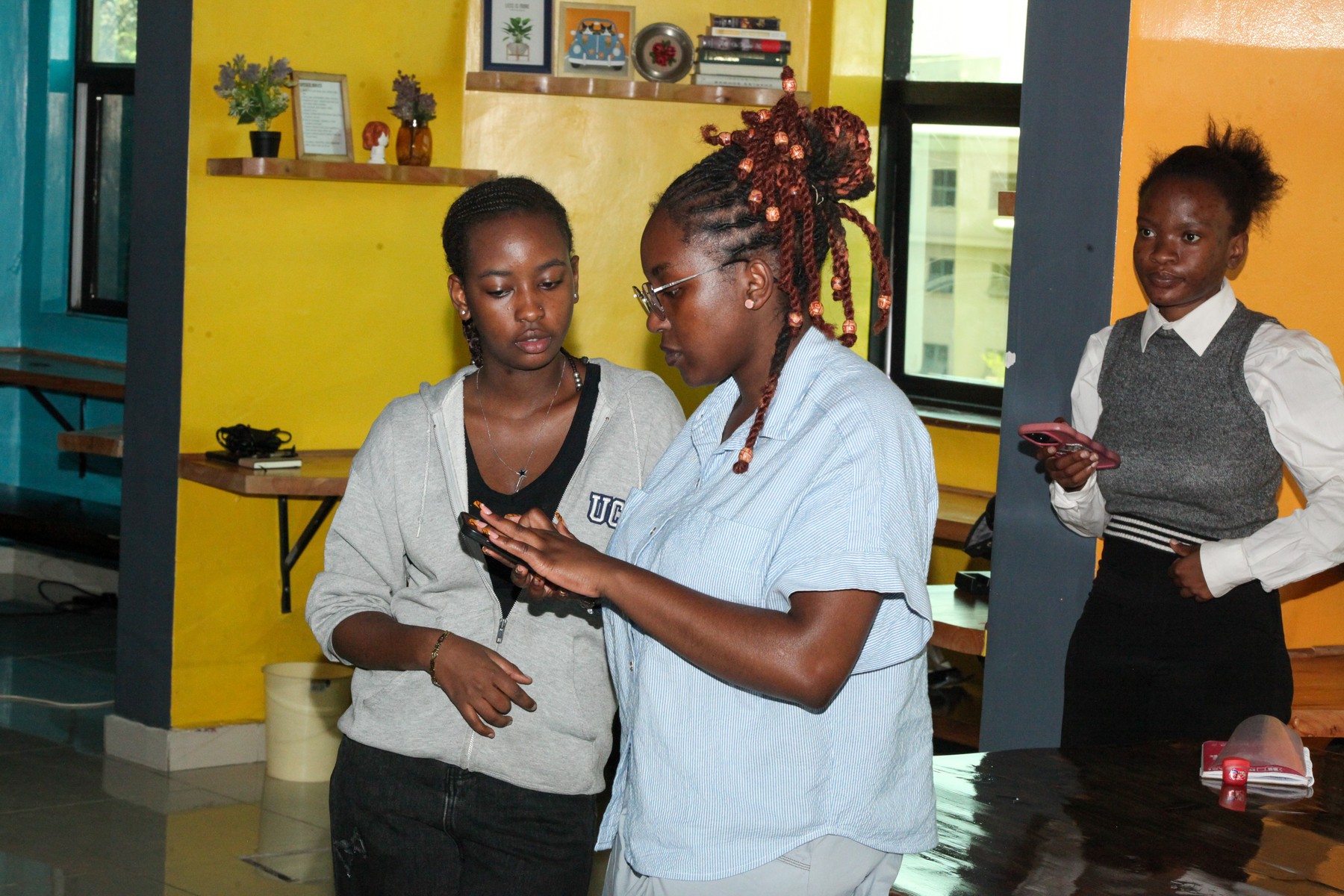 Three women reviewing a phone together