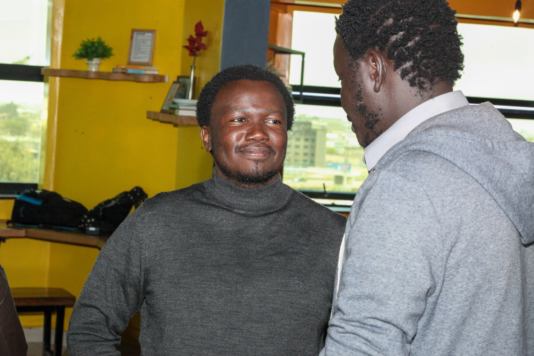 Two men talking face to face in a workroom