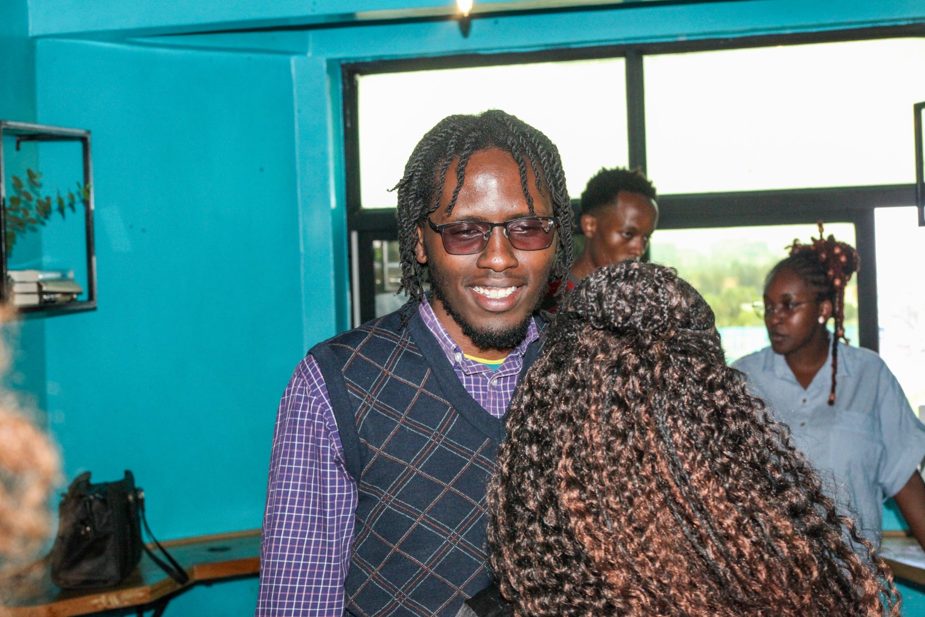 A man with glasses smiling during a conversation