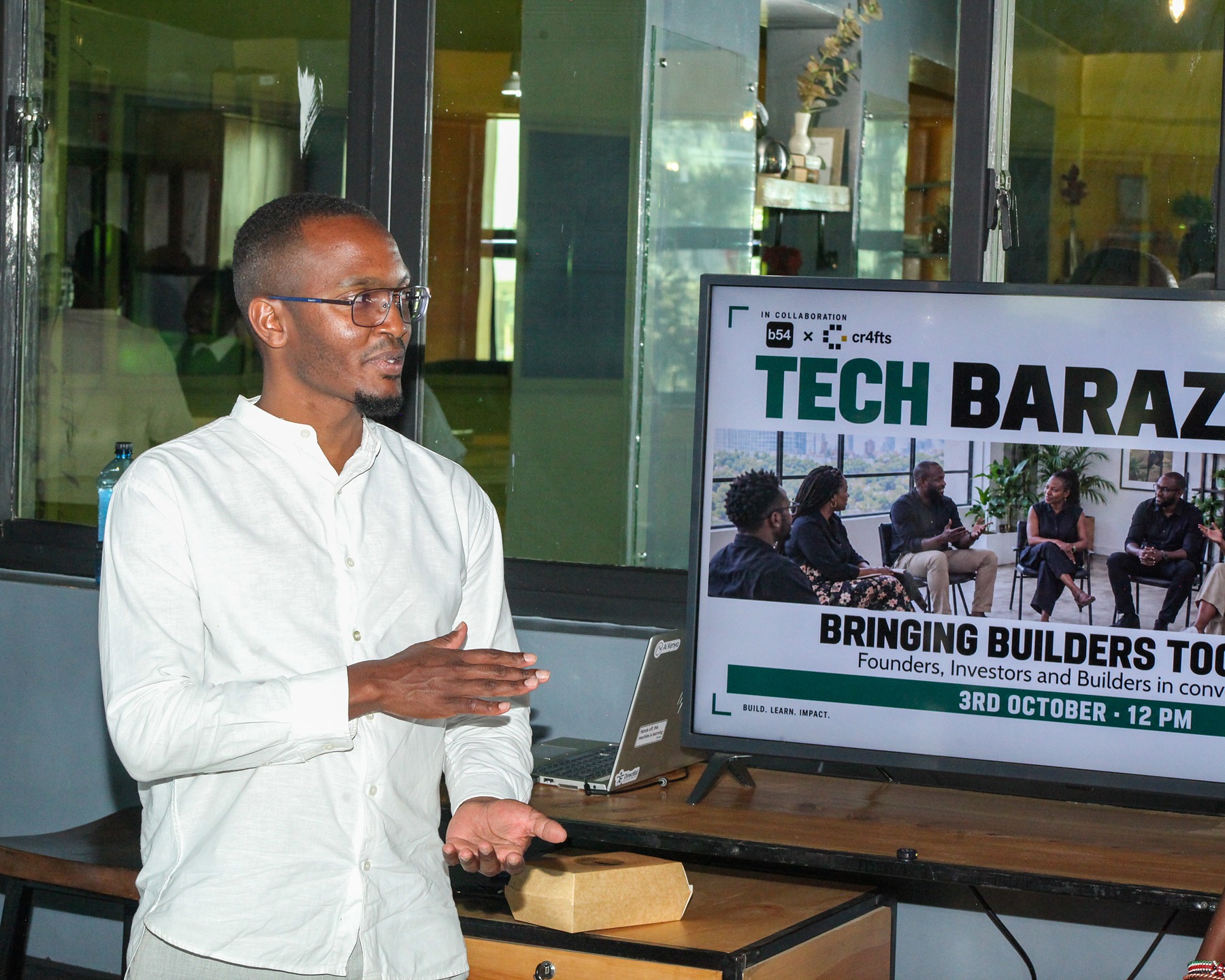 A speaker presenting beside a screen at a Tech Baraza session
