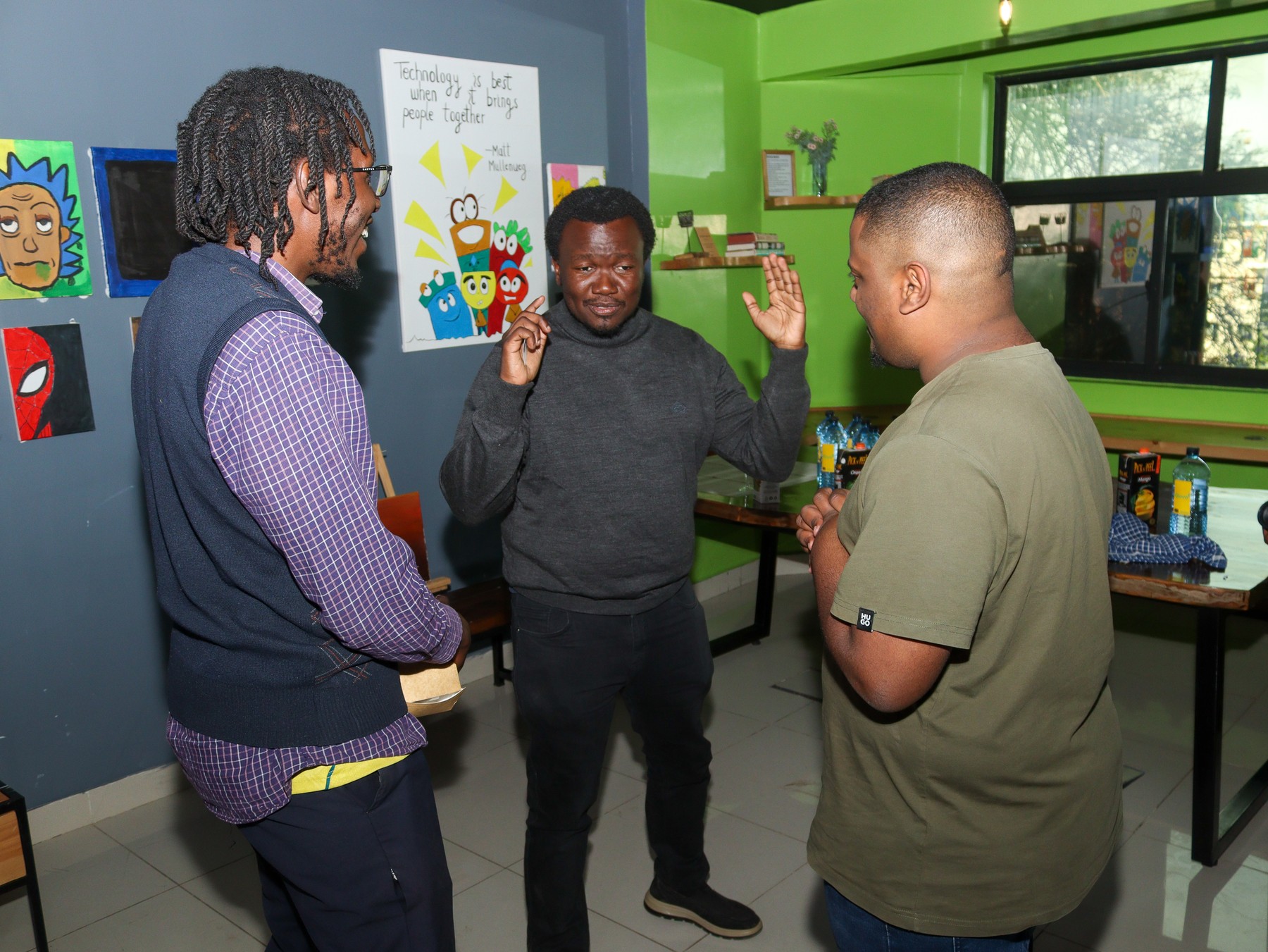 Three men discussing together in a workroom