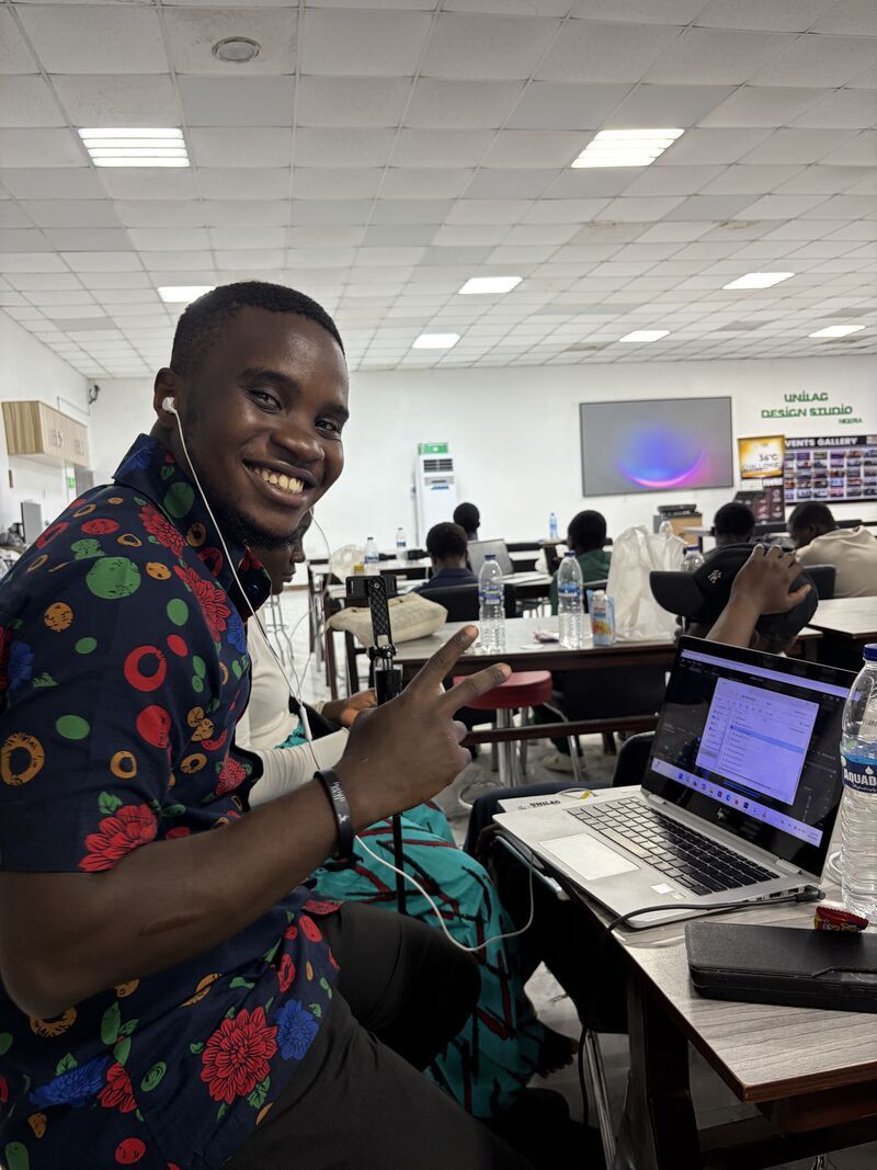 A builder smiling beside his laptop