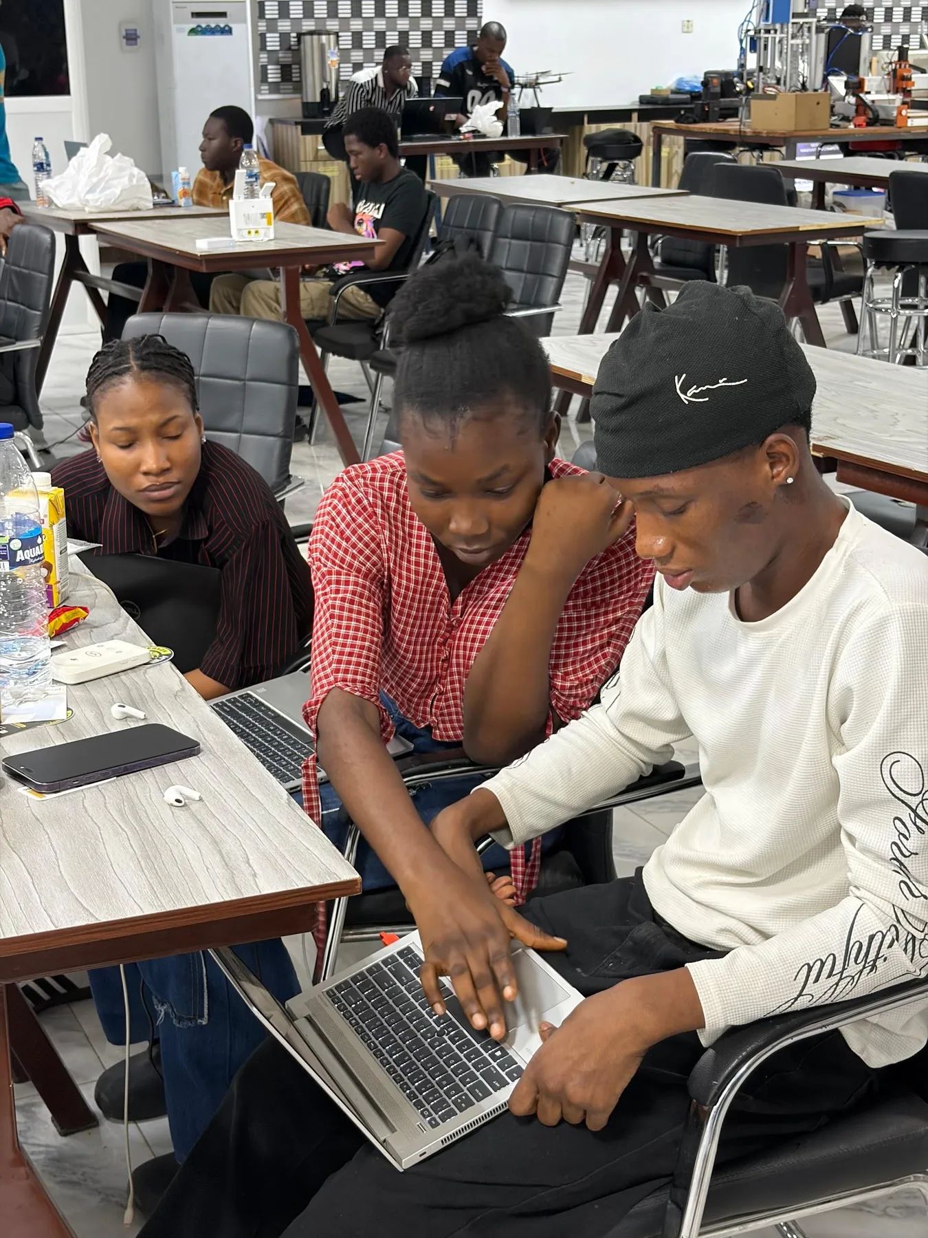 Three builders working through a problem together on one laptop